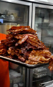 large stack of bacon in the kitchen at Steamy Joe Cafe