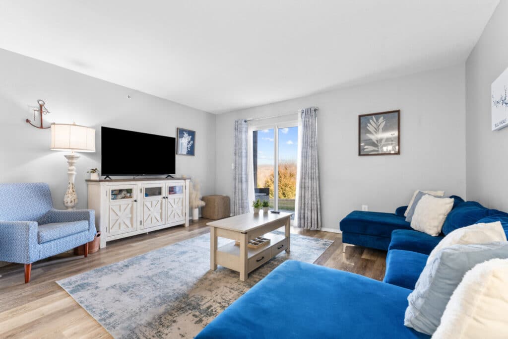Bright condo living room with a navy sectional at connected Branson condos near the Christmas light displays