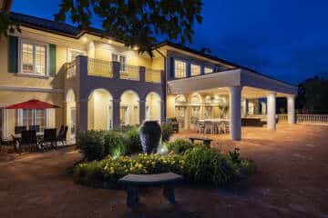 The Bella Vista Estate mansion lit at dusk with its arched patio and landscaped courtyard fountain near Silver Dollar City