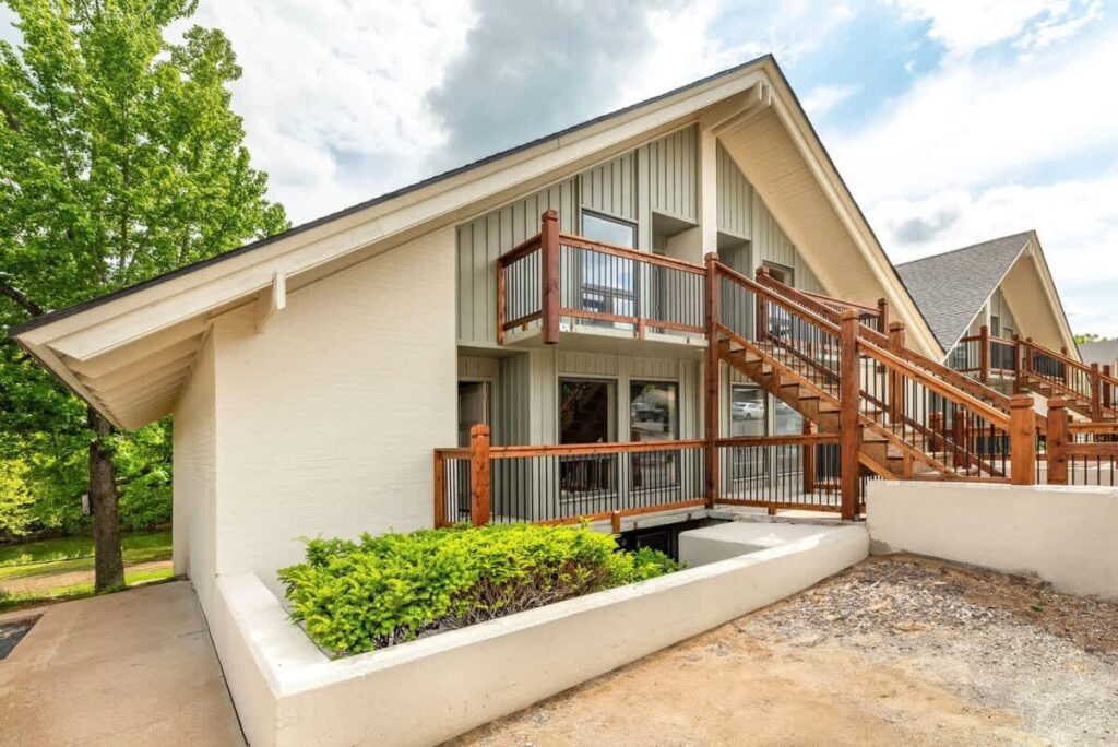 Exterior of the Cozy Modern Condo near Branson Landing, an A-frame building with a wood balcony and staircase