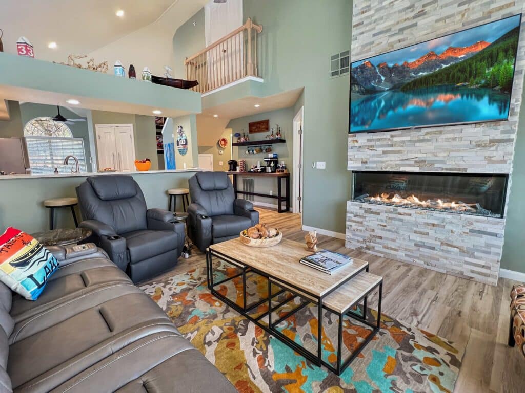 Vaulted living room with a stone gas fireplace and loft in Beach Vibe Condo in Branson, Missouri