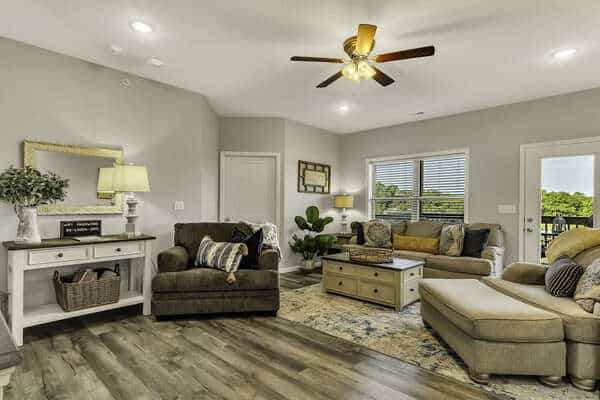 Spacious living room with hardwood floors and a balcony view at Sunset Bunker, a Branson condo decorated for Christmas