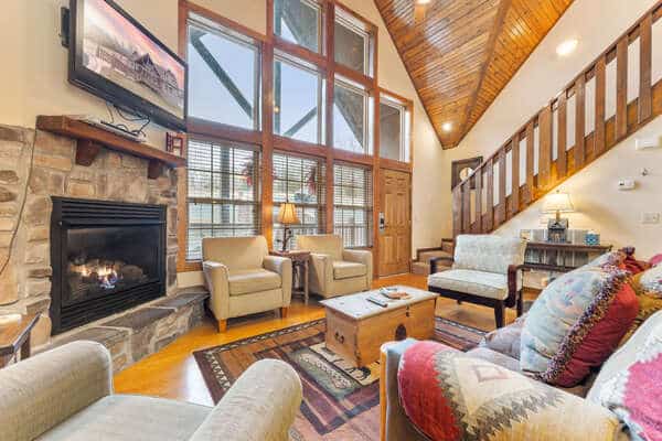 Lit stone fireplace in a Branson rental great room — among Branson rentals, hot tubs and fire pits lead the amenity list