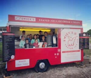 Shane and Niki owners of Swick's Shaved Ice Co Branson Missouri with their family of 12 kids at the red container
