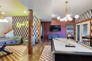 Lower-level game room with pool table in a large Branson luxury vacation rental for family groups