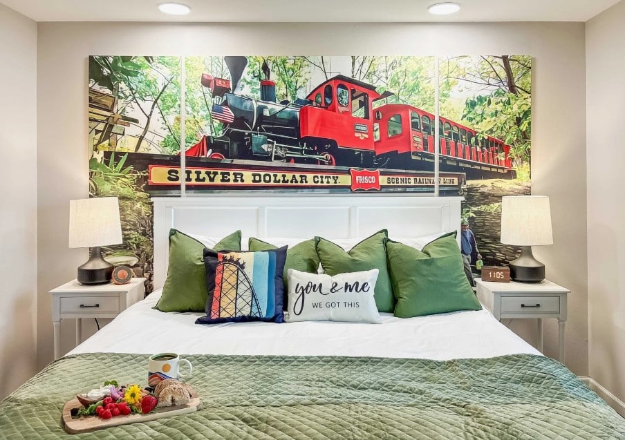 Bedroom with a king bed, green bedding, and a steam-train mural at Bold and Bright Golfside Condo in Branson