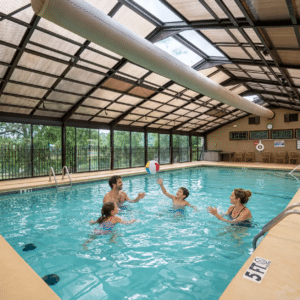 Family swimming in an indoor resort pool, one of the Branson condos with pools open in the fall