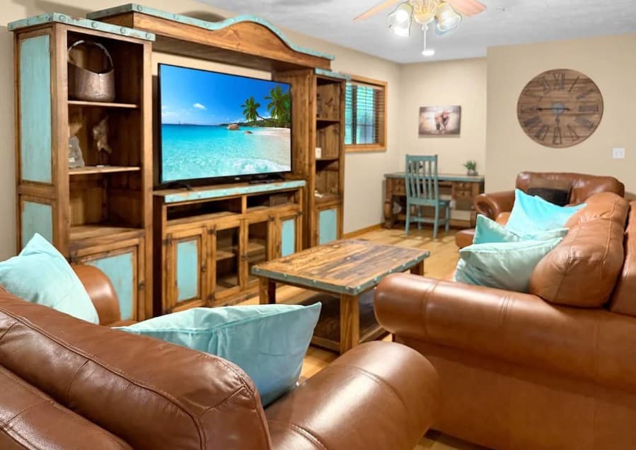 Living room with leather sofas and a wood entertainment center at Close to Big Cedar and Thunder Ridge Family Fun in Ridgedale