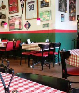 Dining room with Chicago sports decor and red-checked tablecloths at Mr. Gilberti's Place in Hollister, Missouri